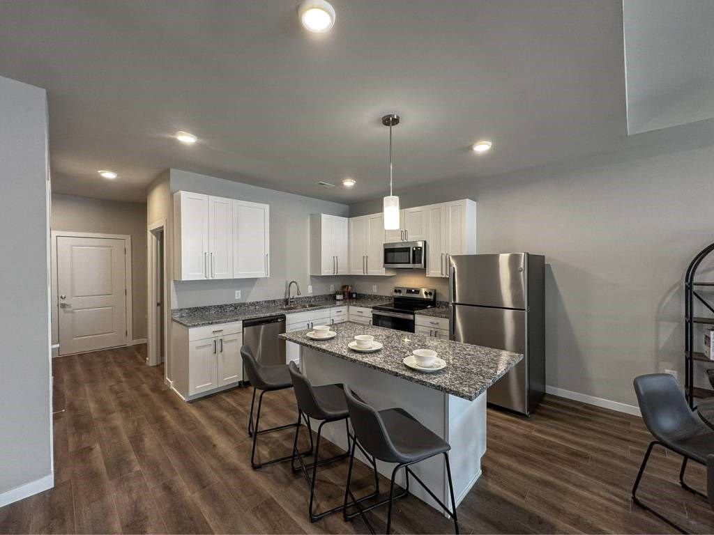 A kitchen with a granite countertop and stainless steel appliances.
