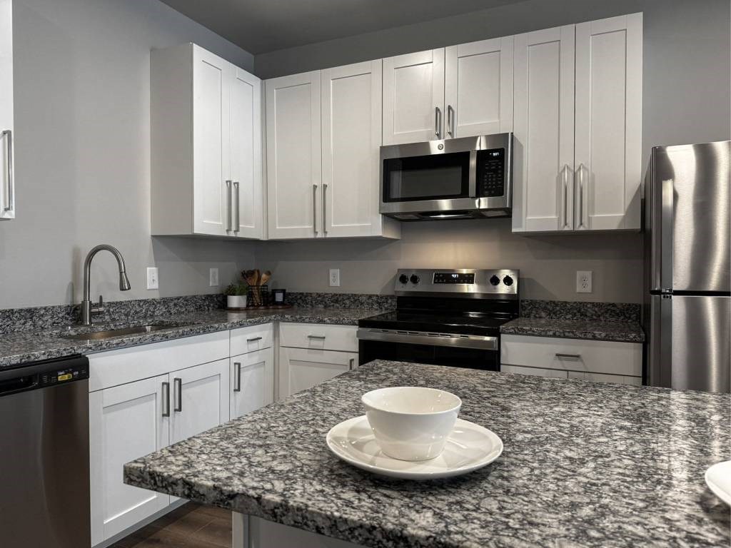 A modern kitchen with granite countertops and stainless steel appliances.