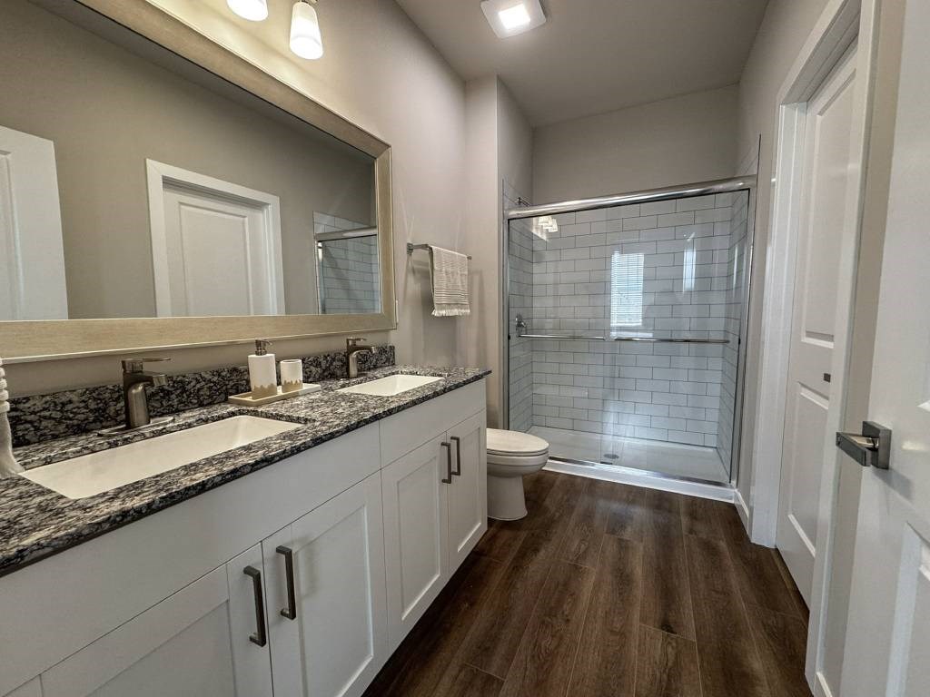 A bathroom with a walk-in shower and double sinks.