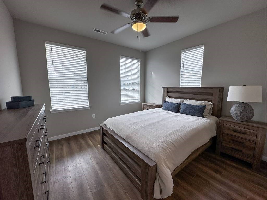 A bedroom with a large bed and a ceiling fan.