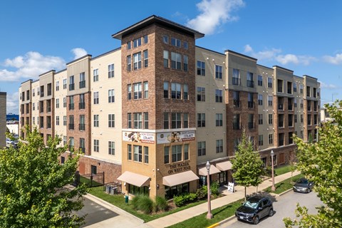 A large apartment complex with a parking lot in front.