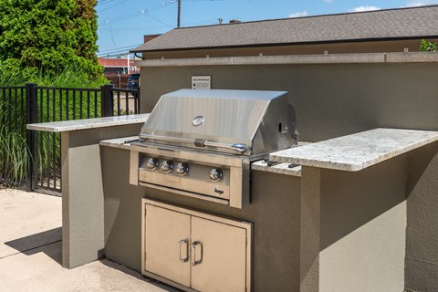 A beige outdoor kitchen with a grill and oven.
