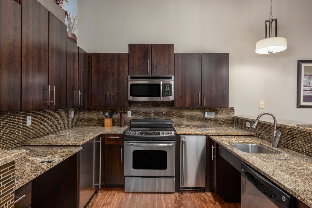 a kitchen with granite counter tops and stainless steel appliances at Lofts at Lafayette Square Apartments, Saint Louis