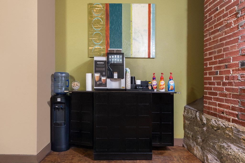 A black shelf with a water cooler and some snacks on it. at Lofts at Lafayette Square Apartments, Saint Louis, Missouri