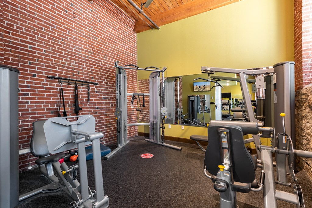 a gym with weights and a brick wall at Lofts at Lafayette Square Apartments, Saint Louis, MO, 63104