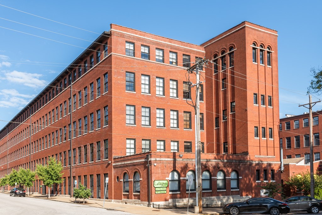 a large red brick building on a city street at Lofts at Lafayette Square Apartments, Missouri, 63104