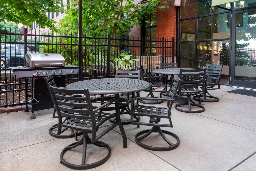 A black metal table and chairs are set up on a patio at Lofts at Lafayette Square Apartments, Saint Louis, MO