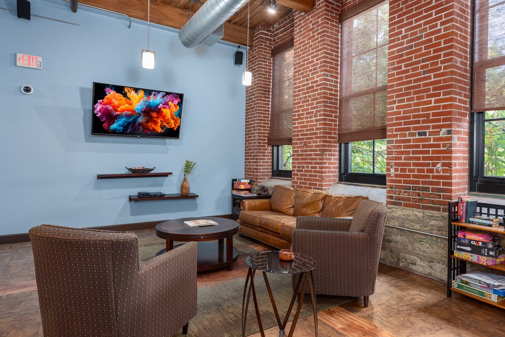 A living room with a couch, chair, and television at Lofts at Lafayette Square Apartments, Saint Louis, MO, 63104