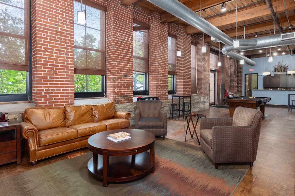 a living room with couches and chairs and a table at Lofts at Lafayette Square Apartments, Missouri, 63104