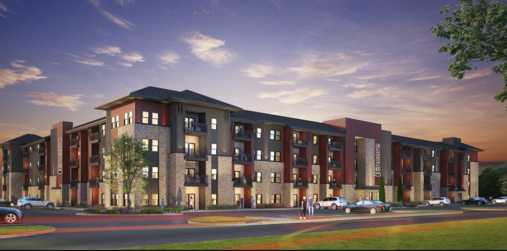 A large, modern apartment building with a parking lot in front.