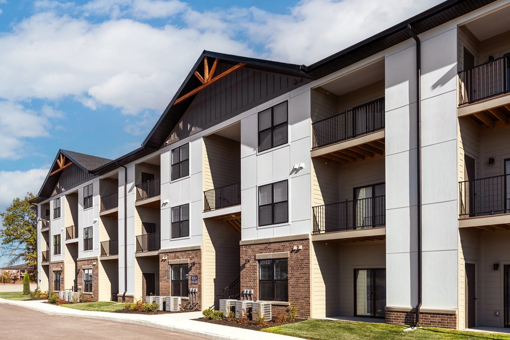 a row of apartment buildings with balconies and a sidewalk