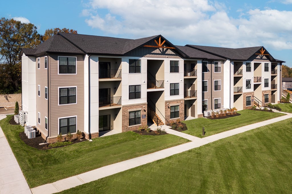 an aerial view of an apartment building on a sidewalk and grass