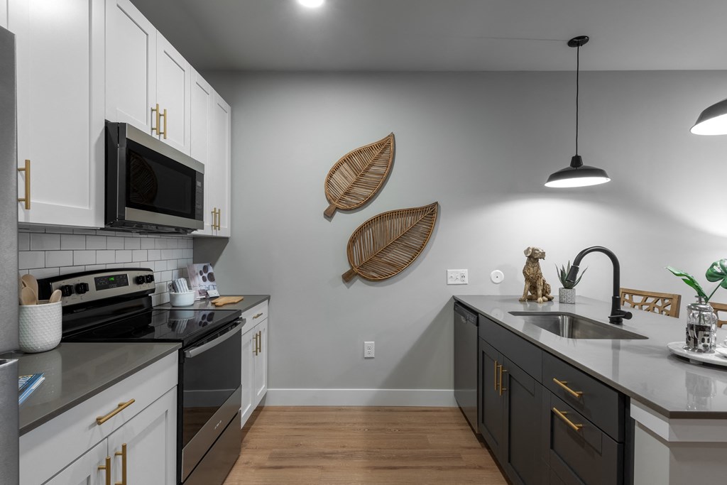 a kitchen with white cabinets and stainless steel appliances and a sink