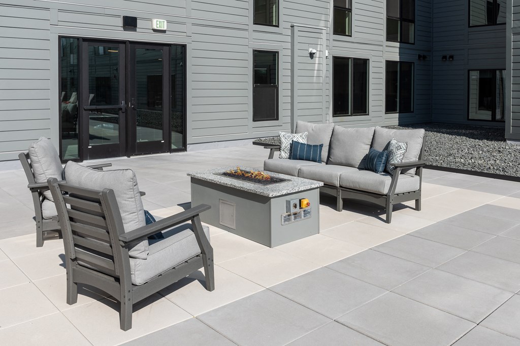 a patio with furniture and a fire pit at The Edwin on Grand Apartments, St Louis, MO
