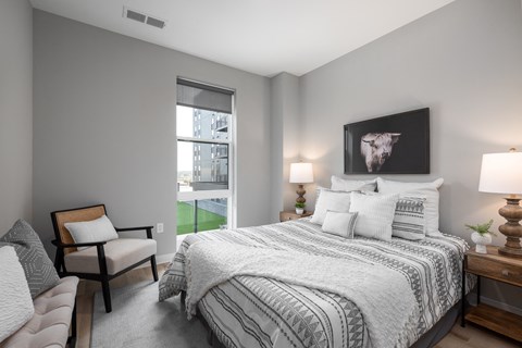 bedroom with gray walls and a large bed with white comforter and pillows at The Edwin on Grand Apartments, St Louis, Missouri