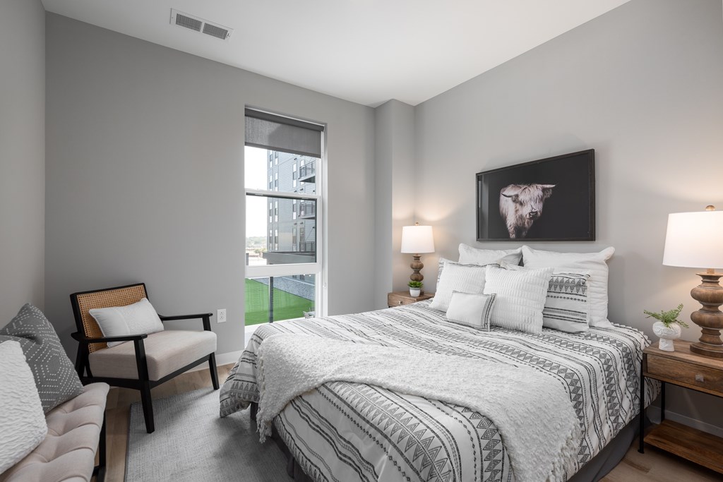 bedroom with gray walls and a large bed with white comforter and pillows bedroom with gray walls and a large bed with white comforter and pillows at The Edwin on Grand Apartments, St Louis, Missouri