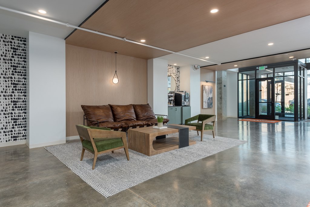 a living room with a couch and chairs and a coffee table at The Edwin on Grand Apartments, Missouri