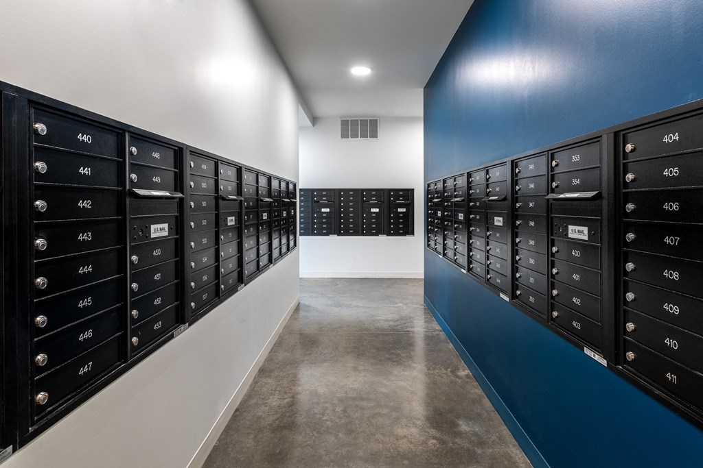 aisles of mailboxes in a room with a blue wall at The Edwin on Grand Apartments, St Louis, Missouri