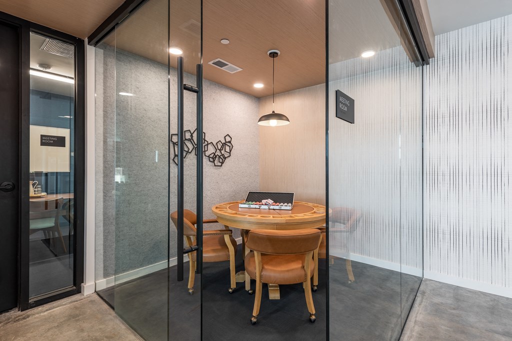 a table and chairs in a room with glass doors at The Edwin on Grand Apartments, Missouri