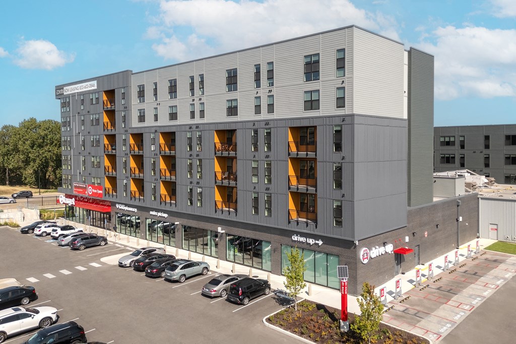 a large apartment building with cars parked in front of it at The Edwin on Grand Apartments, St Louis, MO, 63103
