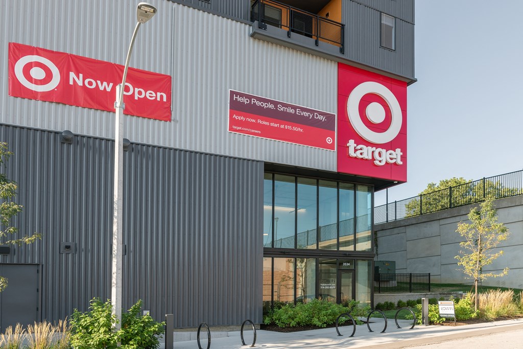 the exterior of a building with two red signs on the side of it at The Edwin on Grand Apartments, Missouri, 63103