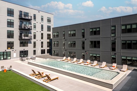 a swimming pool in the middle of two apartment buildings at The Edwin on Grand Apartments, Missouri