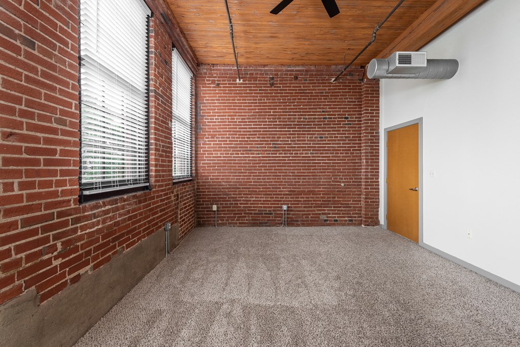 an empty room with a brick wall and a window at Lofts at Lafayette Square Apartments, Saint Louis, MO