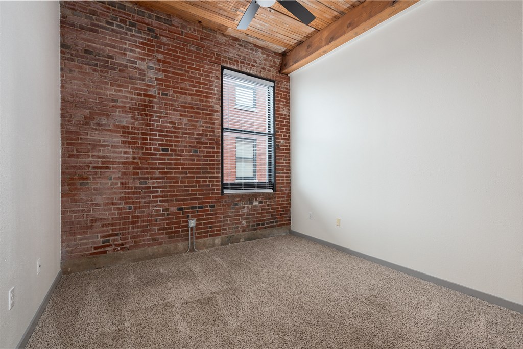 an empty room with a brick wall and a window at Lofts at Lafayette Square Apartments, Missouri, 63104