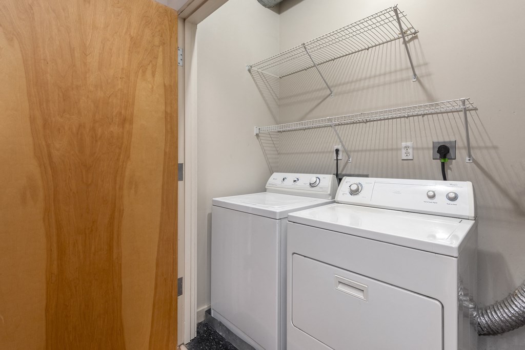 the laundry room has a washer and dryer and a door to the closet at Lofts at Lafayette Square Apartments, Saint Louis, MO, 63104