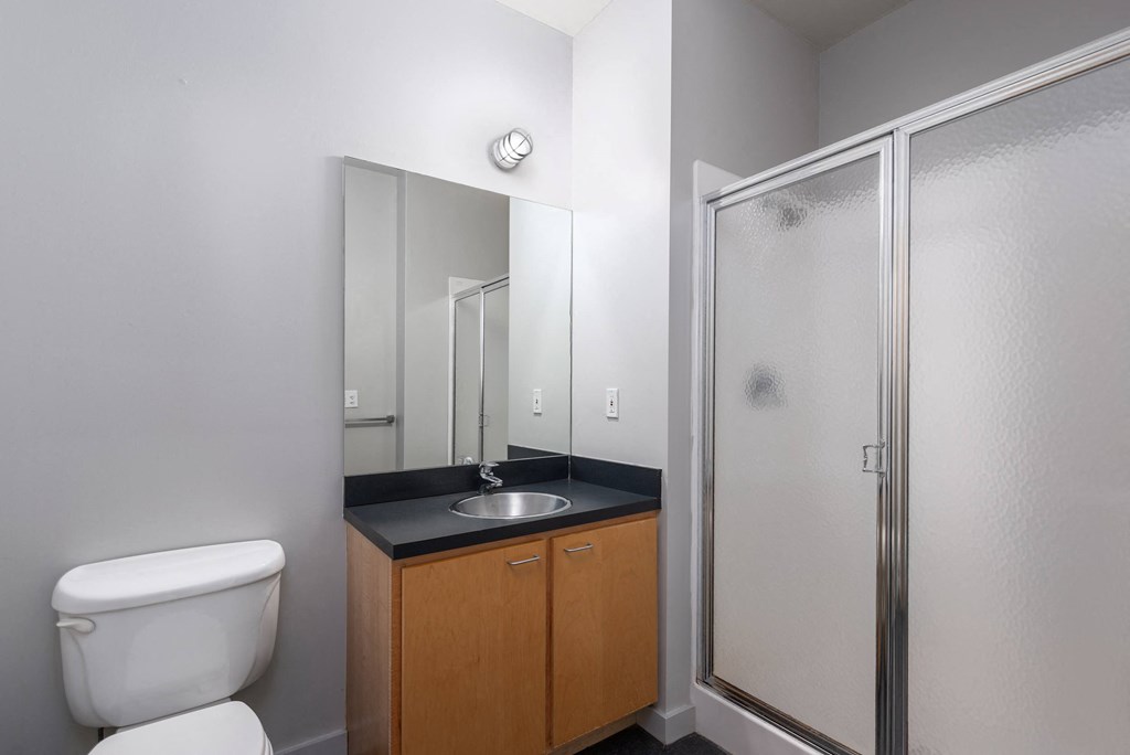 an empty bathroom with a toilet sink and shower at Lofts at Lafayette Square Apartments, Missouri