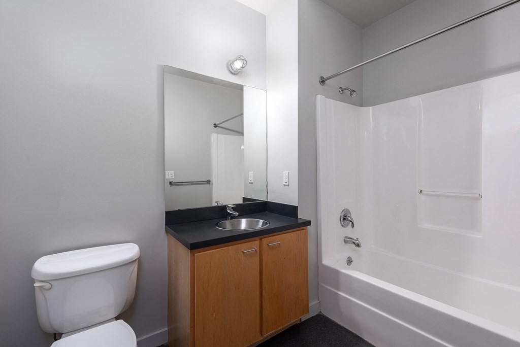 A white toilet sits next to a sink in a bathroom at Lofts at Lafayette Square Apartments, Saint Louis, MO