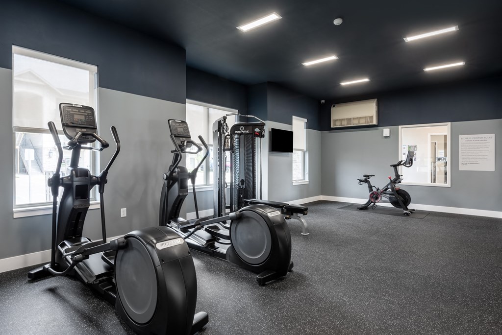 a gym with cardio equipment and weights in a building at The Station St. Peters, Missouri