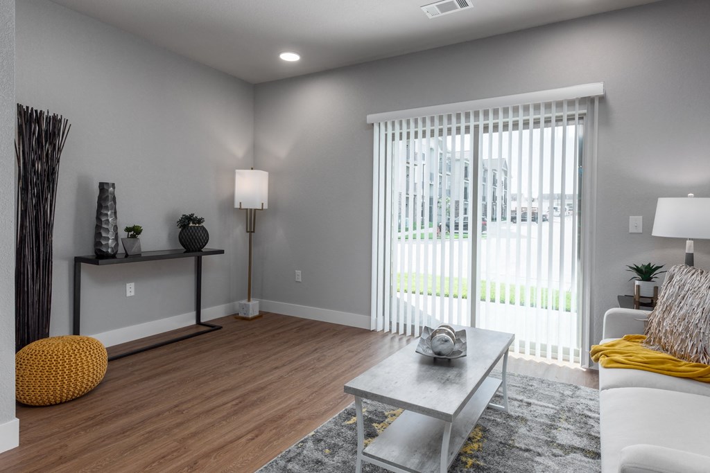 a living room with a large window and a couch and a coffee table at The Station St. Peters, St. Peters, 63376