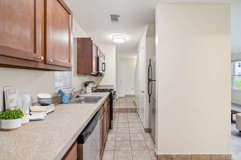 A kitchen with brown cabinets and a counter with a plant, a bowl, and a sign that says "flour salt".