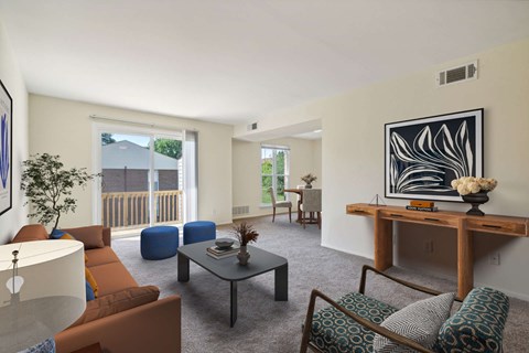 A living room with a brown couch, a coffee table, and a painting on the wall.