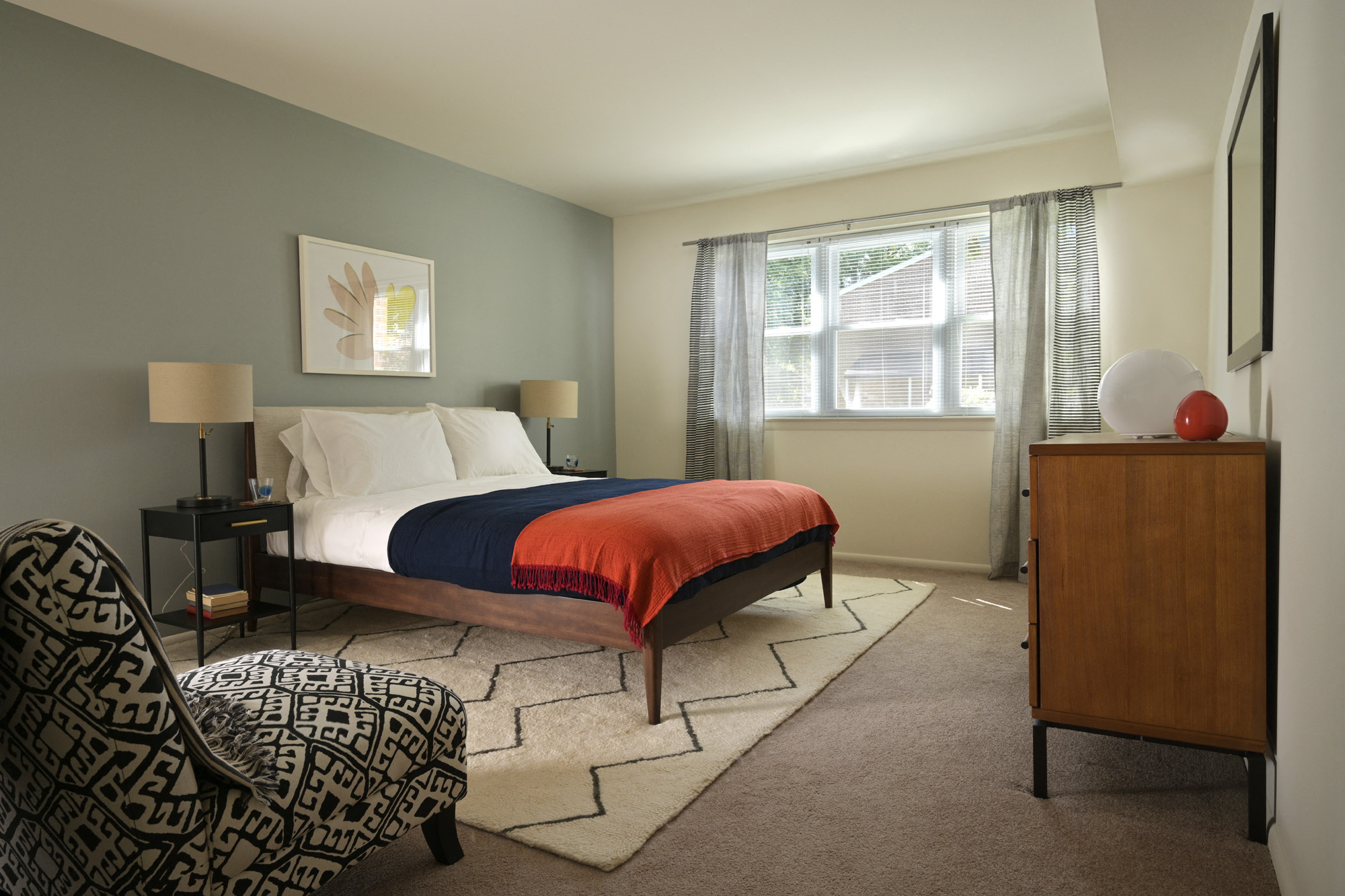 Room with made bed, carpet, furniture