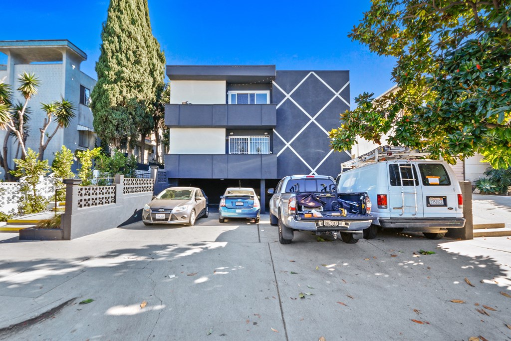 an apartment building with cars parked in front of it