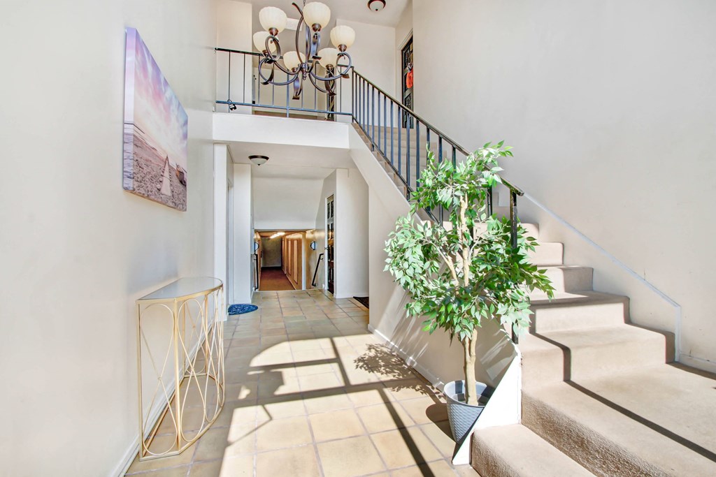the entryway of a house with stairs and a plant