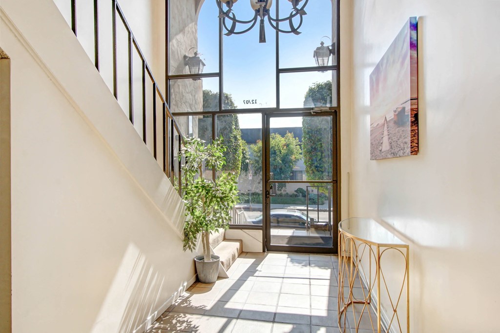 a hallway with a staircase and a large glass door