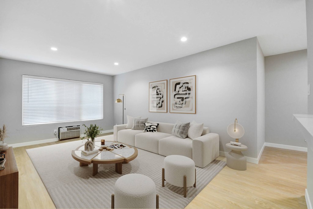A living room with a white couch, a coffee table, and a rug.
