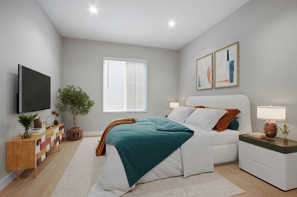 A bedroom with a bed, nightstands, and a television.