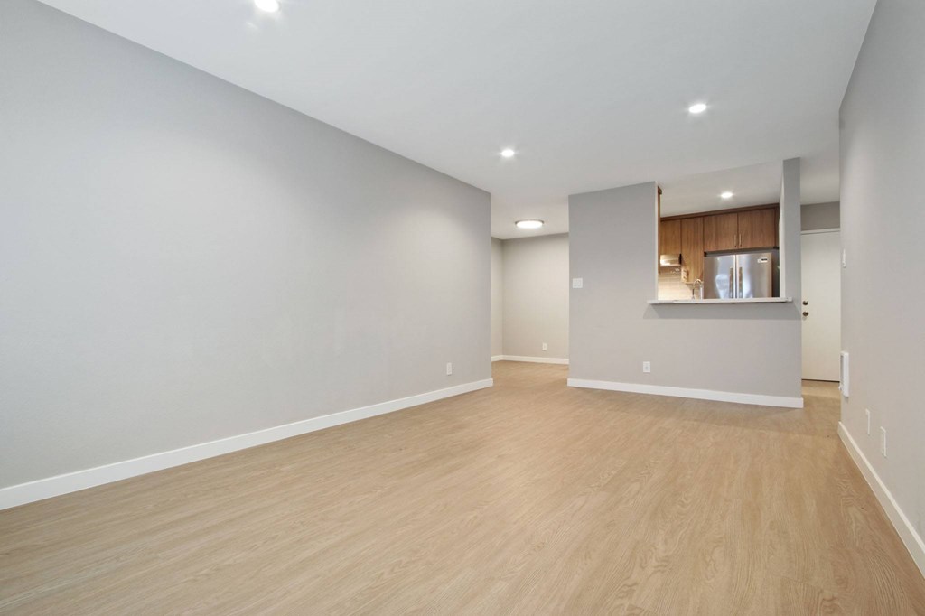 A room with wooden flooring and white walls.