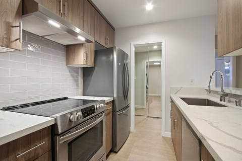 A kitchen with a stove top oven and a refrigerator.