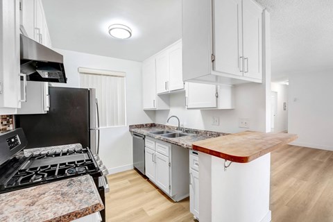 A kitchen with a black stove top oven and white cabinets.