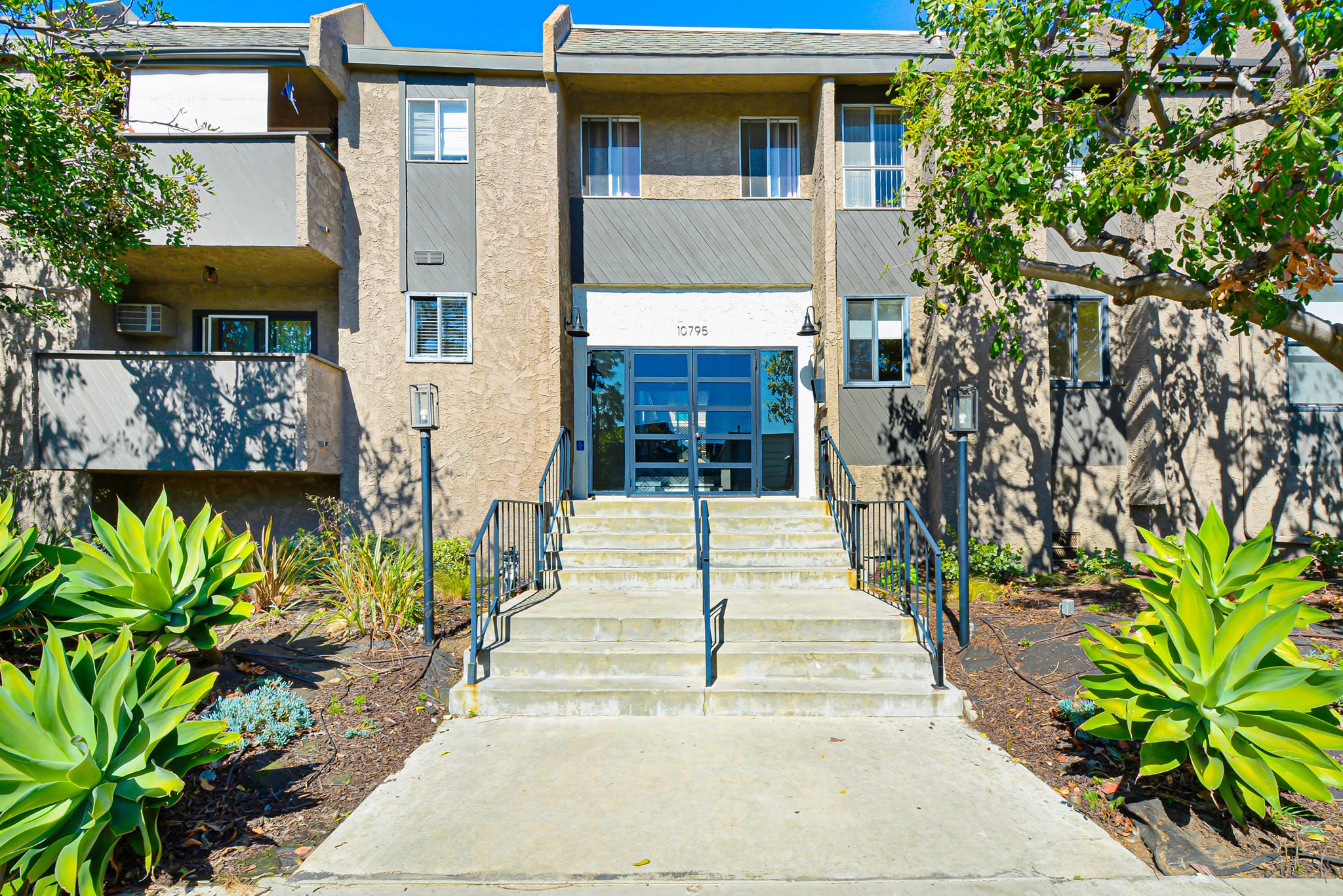 A building with a grey facade and a glass door entrance.