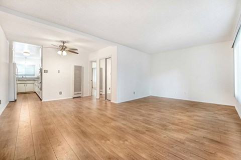 A room with wooden flooring and a ceiling fan.