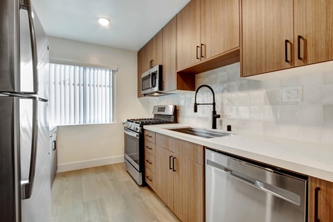 A kitchen with wooden cabinets and stainless steel appliances.