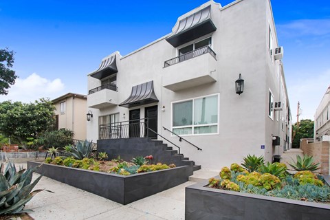 A modern house with a white exterior and a black roof.