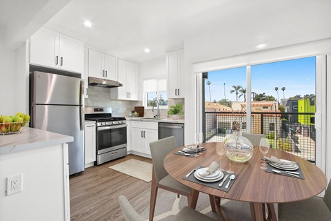 A modern kitchen with a dining table set for two.
