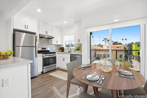 A modern kitchen with a dining table set for two.